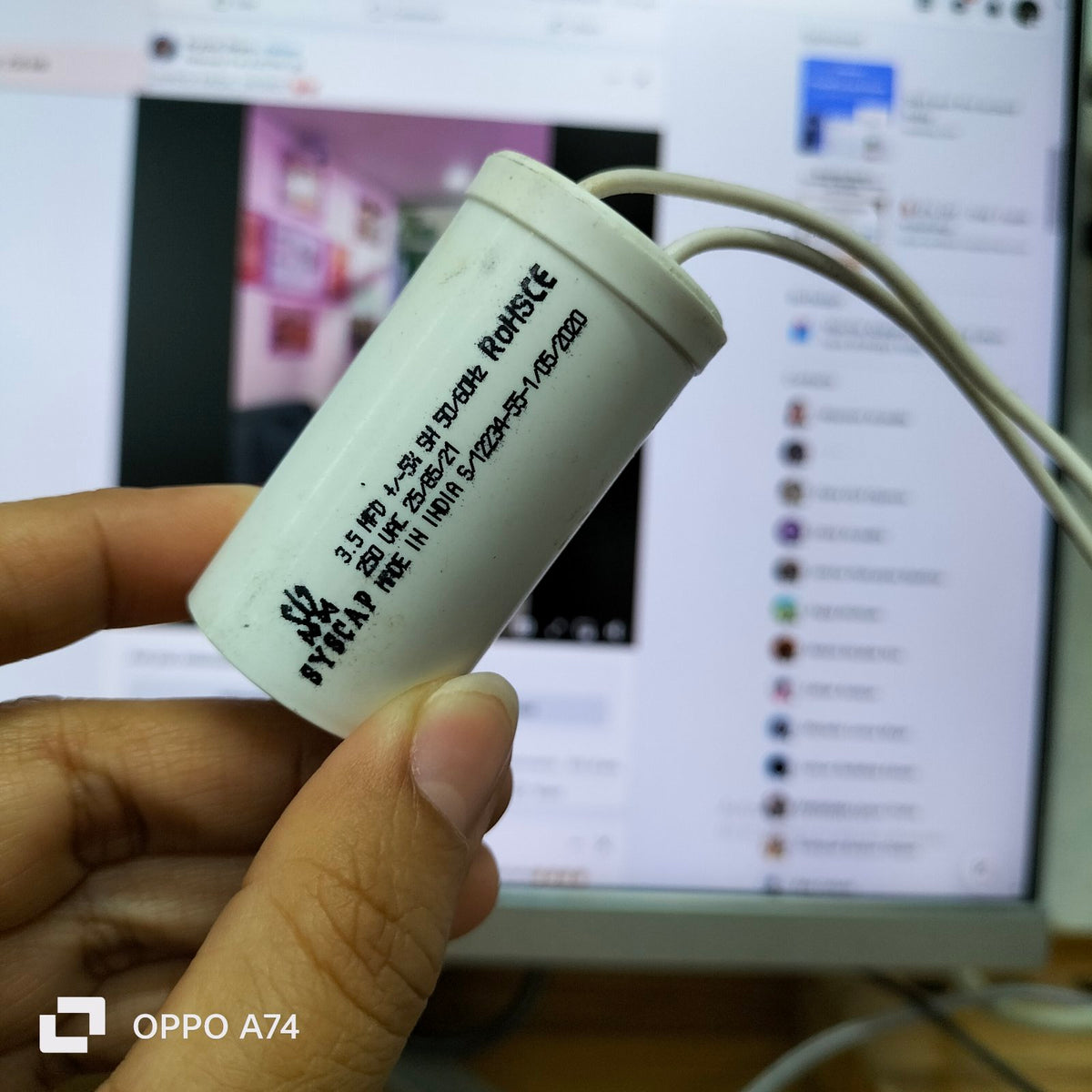 250V AC Motor Running Capacitor by Syscap held in hand with visible markings on white casing