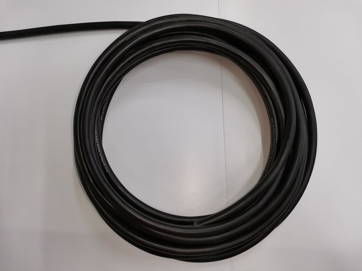 Coiled 3 meter 2.0mm 2 core royal cord wire by Phelps Dodge in black on white background