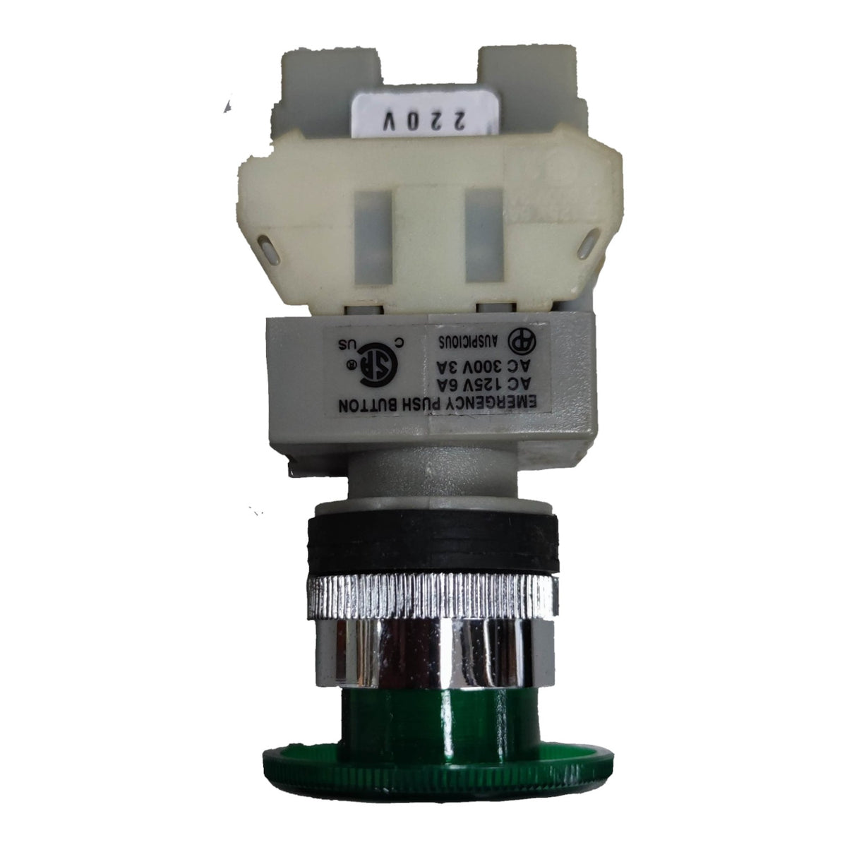 An industrial electrical push button assembly with a green base, a silver and black ribbed metal stem, a gray housing, and a cream-colored plastic top connector block. The button is labeled 'EMERGENCY PUSH BUTTON' with technical specifications, and the top has a white sticker reading '220V'.