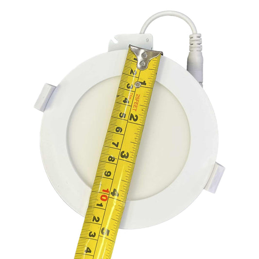Round light fixture with a measuring tape indicating its dimensions on a white background