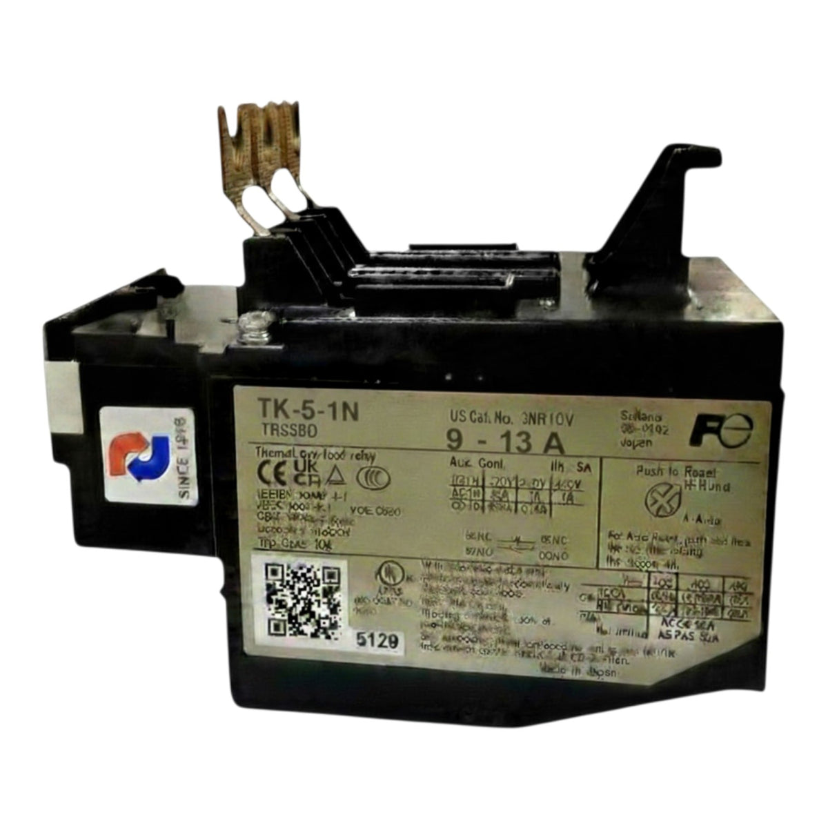 A black electrical contact breaker with a large white label containing technical specifications and a QR code, featuring brass and black terminal clips on top.