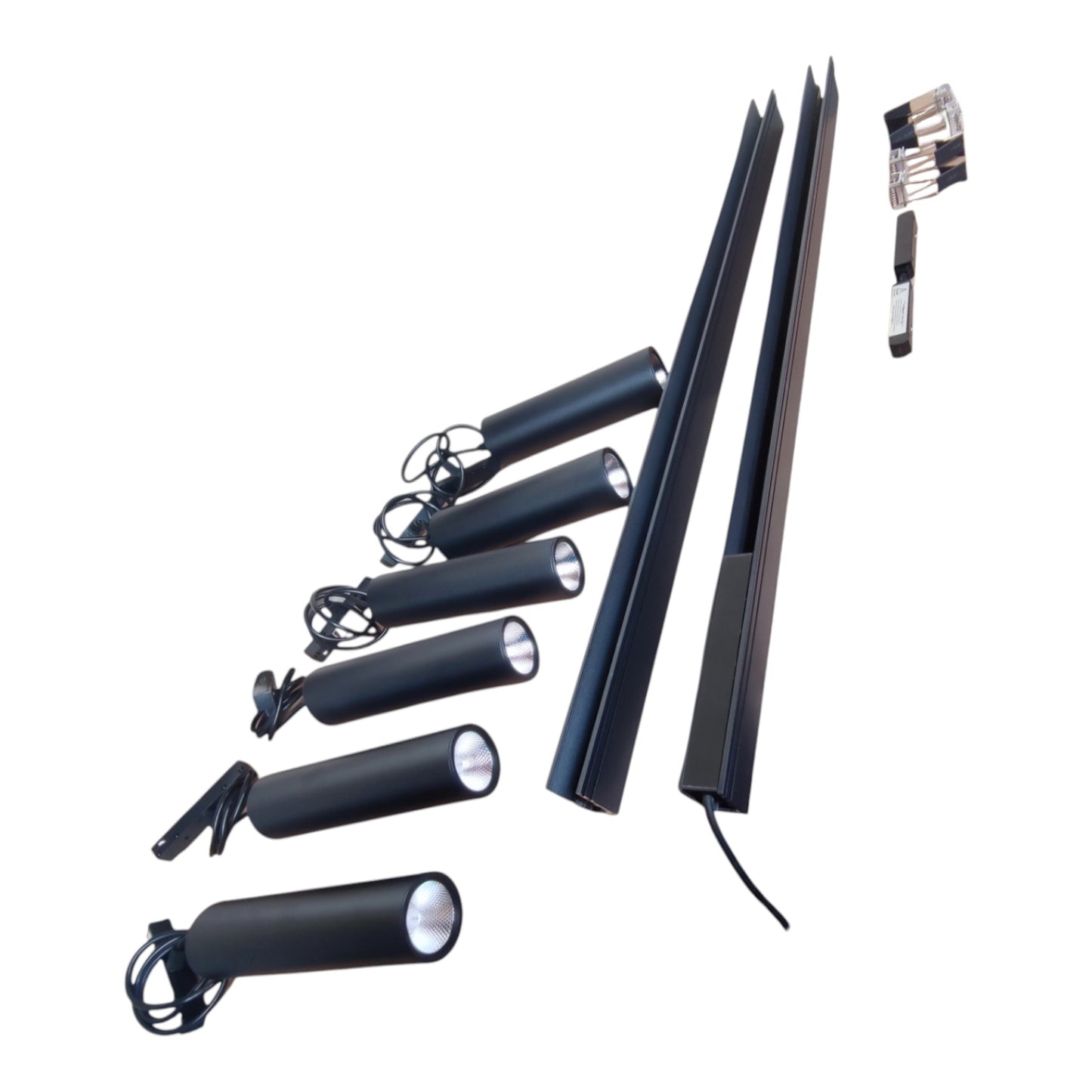 A set of black cylindrical spotlight fixtures with adjustable heads, shown with long mounting rails and a small accessory tool on a plain white background.