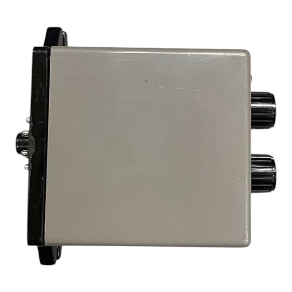 A square electronic control box with a beige-gray plastic casing, black mounting brackets on the sides, and two black rotary knobs on the right side.