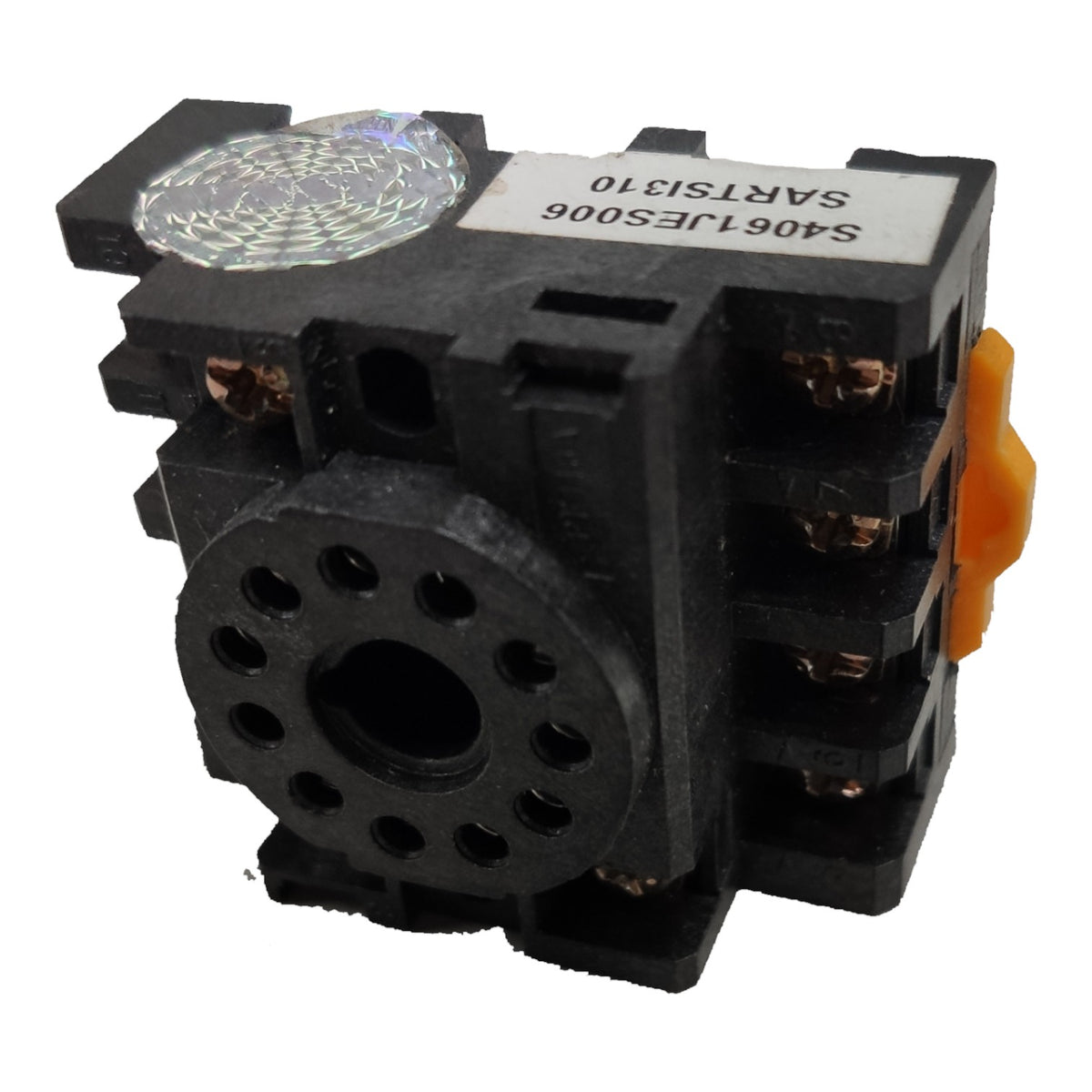 A black electrical relay component with a circular front terminal plate, copper-colored screw terminals, a holographic sticker on top, and an orange push-button switch on the side, isolated on a white background.