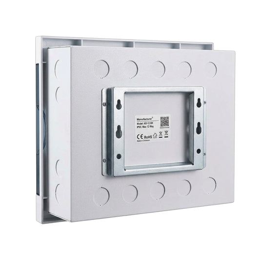 A silver metal mounting bracket or enclosure plate with circular cutouts and a central recessed panel showing a small product label, photographed on a plain white background.