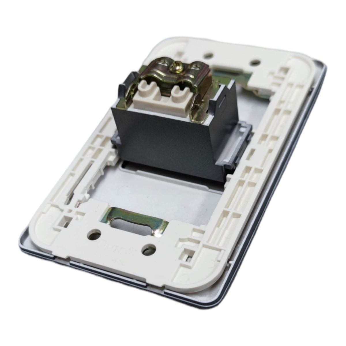 A close-up of a white plastic electrical switch plate or socket backplate with exposed internal components, including a black block and metal terminals, shown on a plain white background.