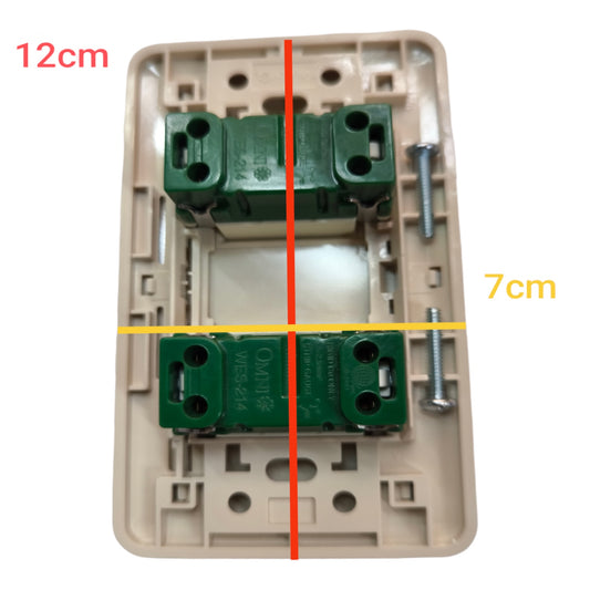 A beige plastic switch socket backplate with two green terminal blocks and mounting screws, overlaid with red and yellow measurement lines and text reading 12cm and 7cm on a white background.
