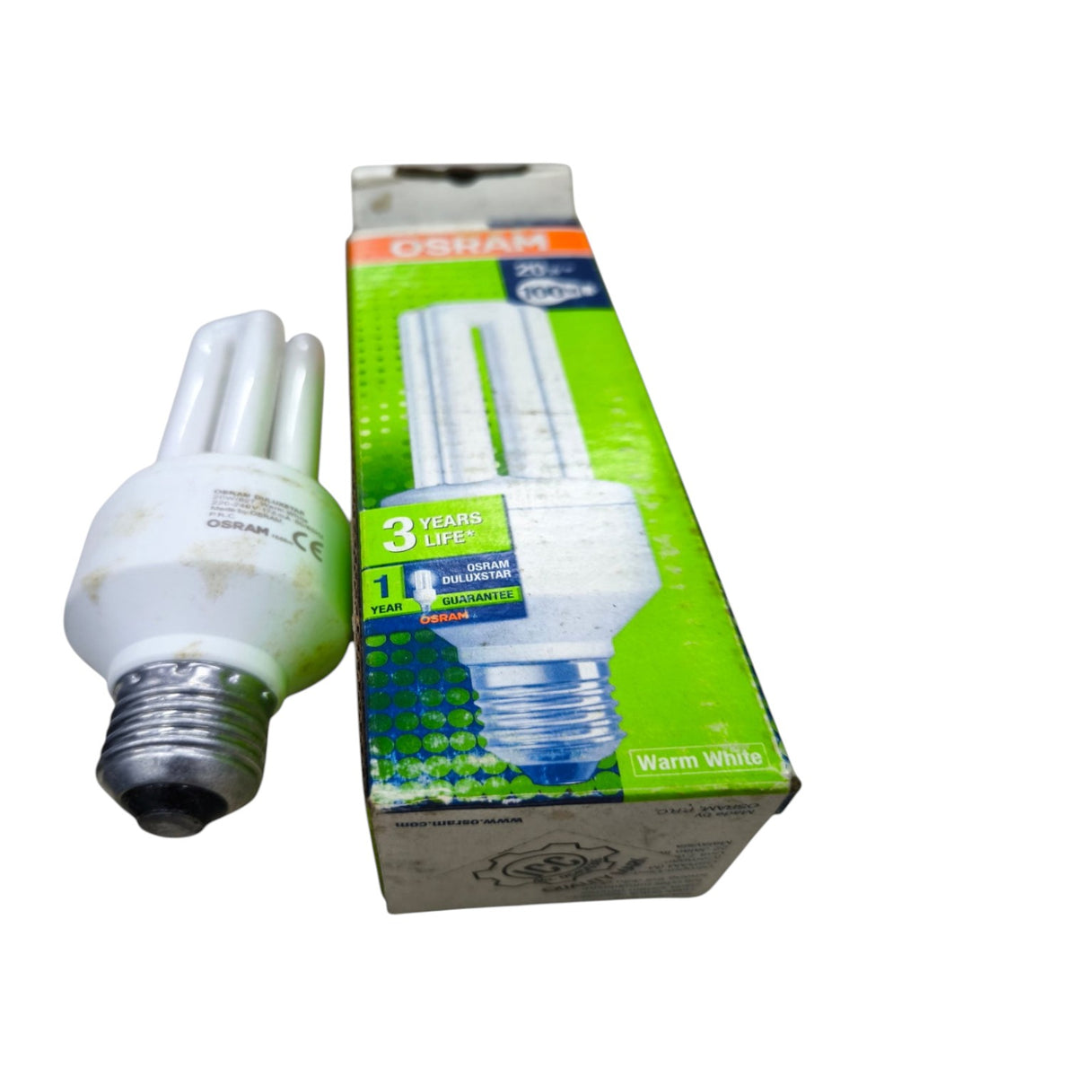 An Osram compact fluorescent light bulb next to its green and white retail packaging box, set against a plain white background.