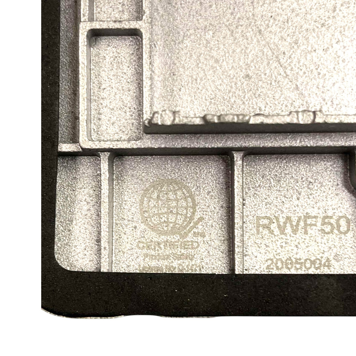 Close-up of a gray cast-metal automotive part with molded cavities, featuring a stamped 'OEM Verified' logo and part number 'RWF50 2065004'.