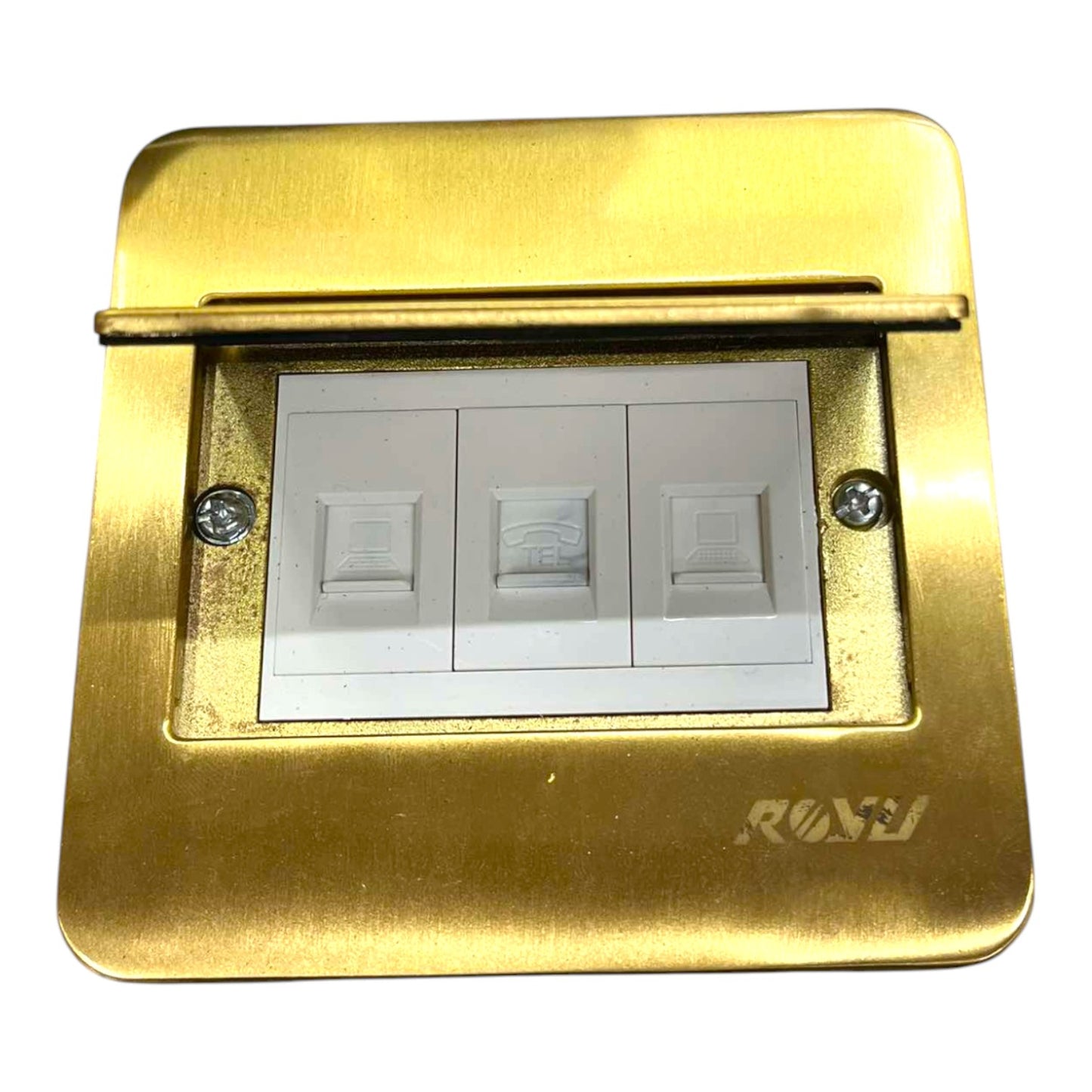 A brass three-gang light switch plate cover with white switch modules inside, featuring a hinged top cover and a debossed 'RAV' brand logo on the bottom right.