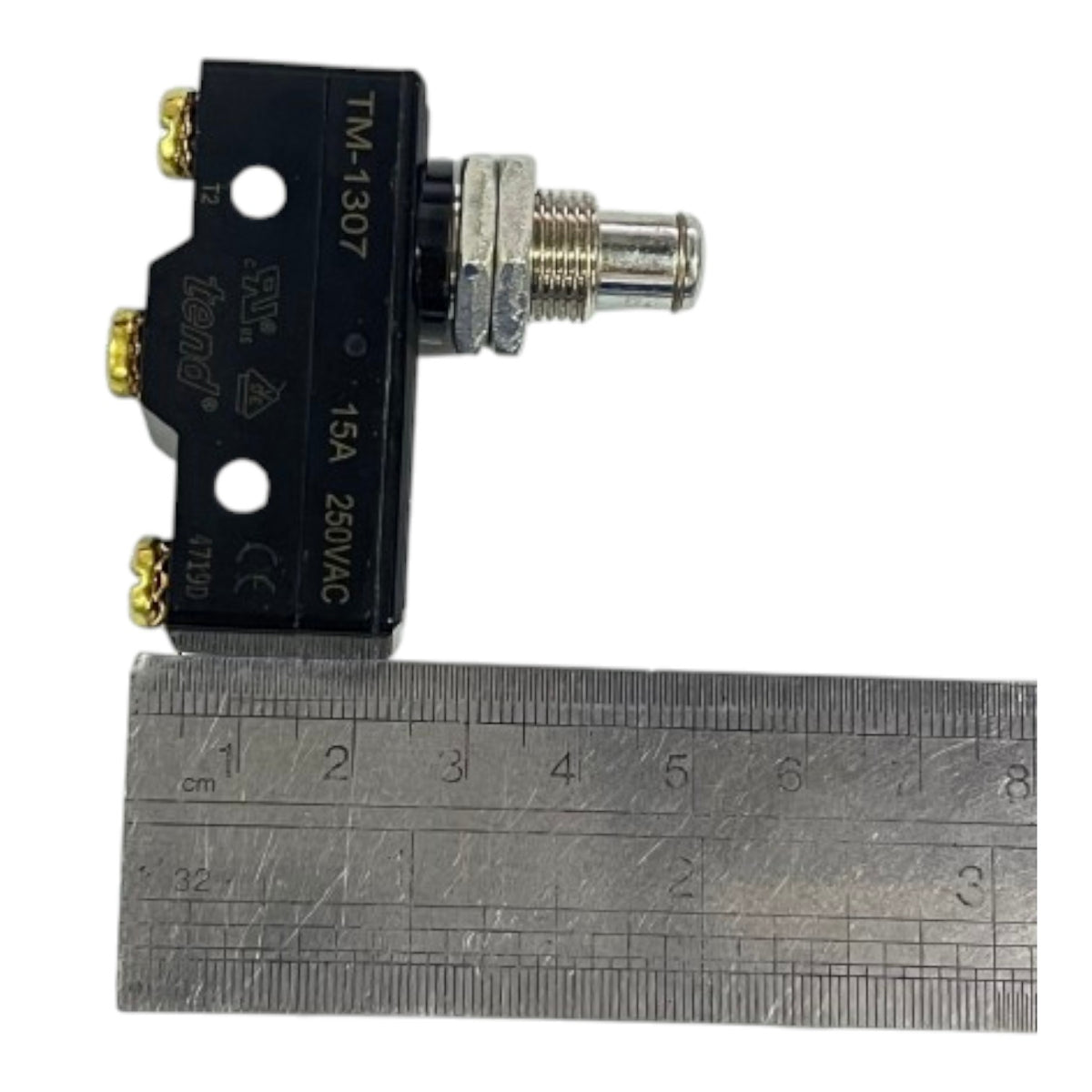 A small black electrical component with a threaded metal connector and gold-toned terminal screws, shown next to a metal ruler for scale on a white background.