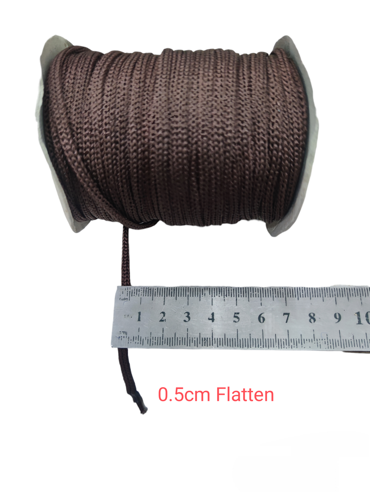 Brown cloth rope rolled on spool with 0.5 cm width next to ruler measuring cloth rope per meter