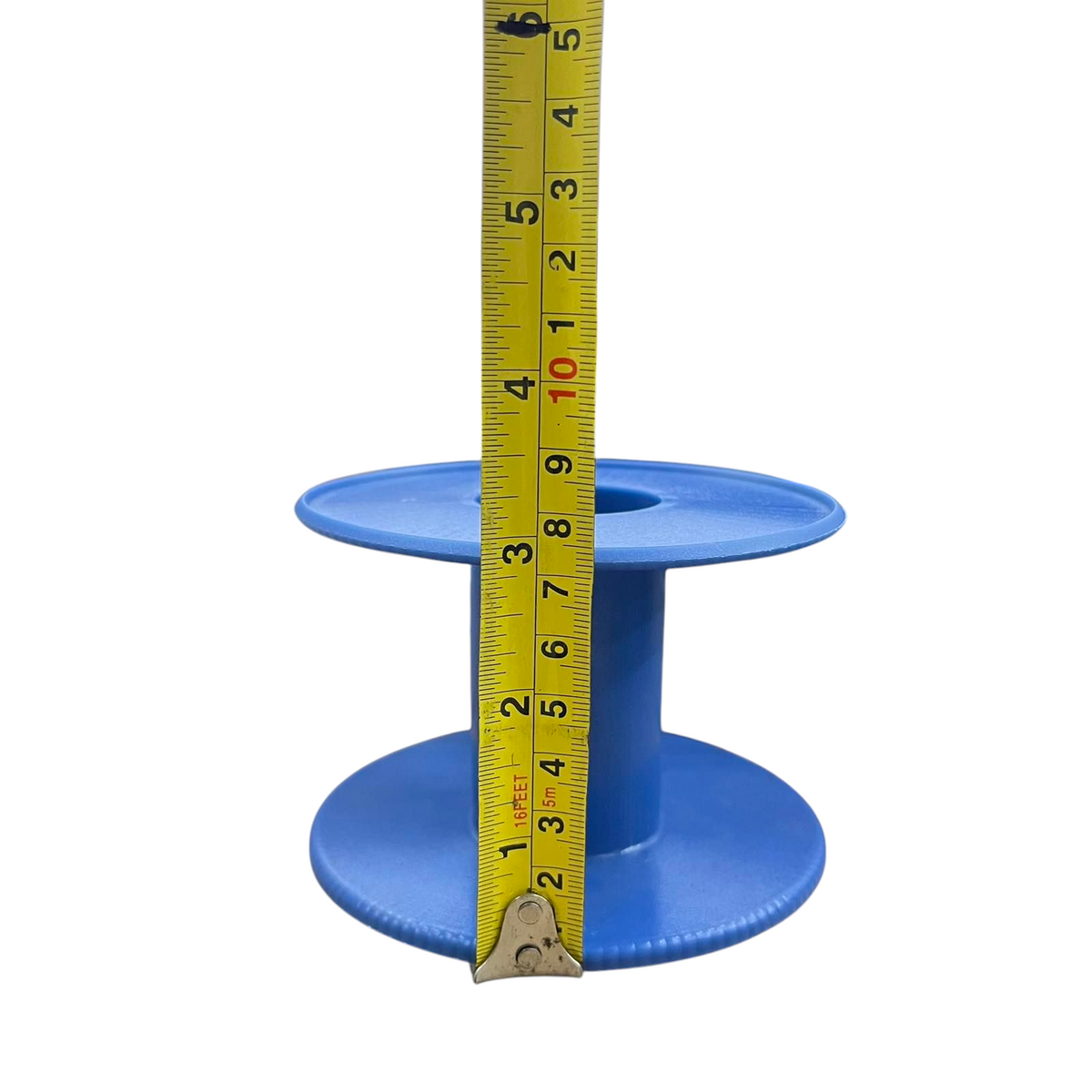 Blue empty 5 lbs plastic wire spool on white background with measuring tape showing height for crafts