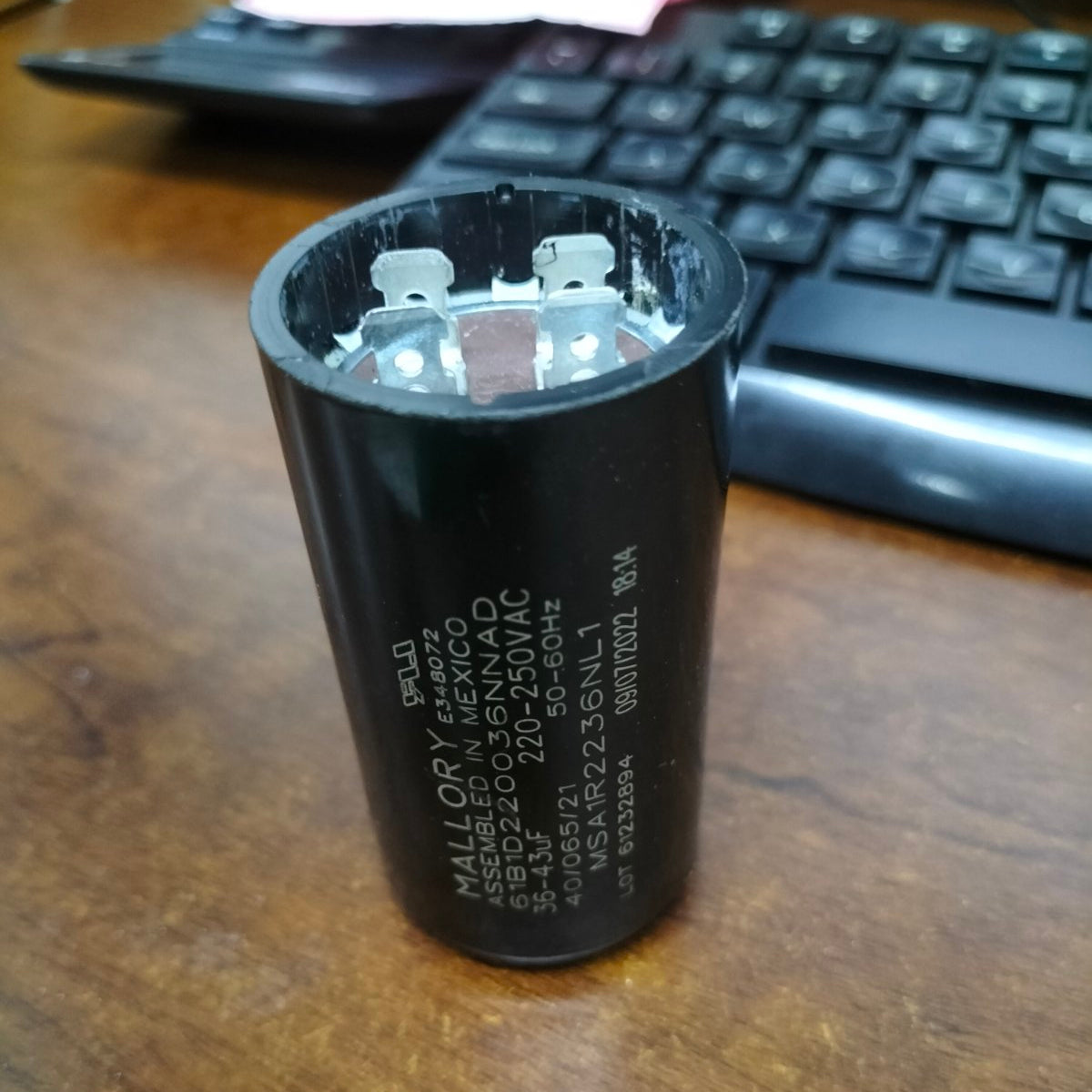 Mallory 36-43UF 220-250VAC motor capacitor on wooden desk with computer keyboard in background