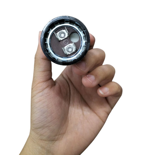 Mallory Motor Capacitor held in hand showcasing its compact design and electrical connections