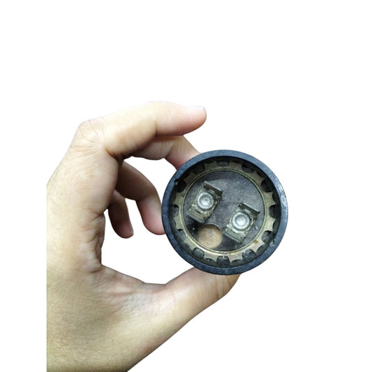Mallory Starting Capacitor 72-86MFD held in hand showcasing its round design and connection points
