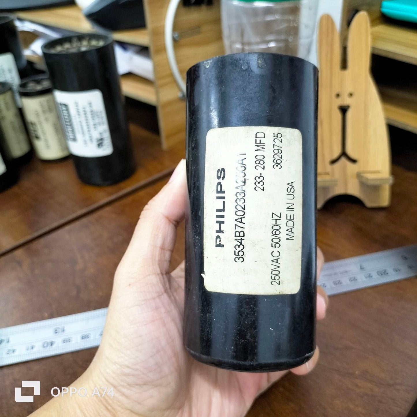 Philips Motor Starting Capacitor 233-280UF black cylindrical fan part held in hand for fan repairs