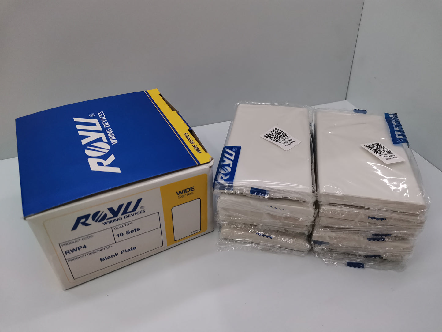 Royu Blank Faceplate Cover Plate packs showing stacked white plates and branded packaging box for power points switches and plugs