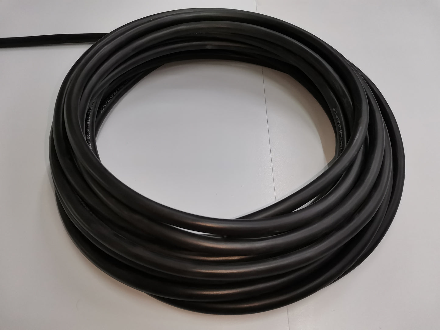 Phelps Dodge royal cord 3.5mm 2 core wire 50 meters coiled on a white surface
