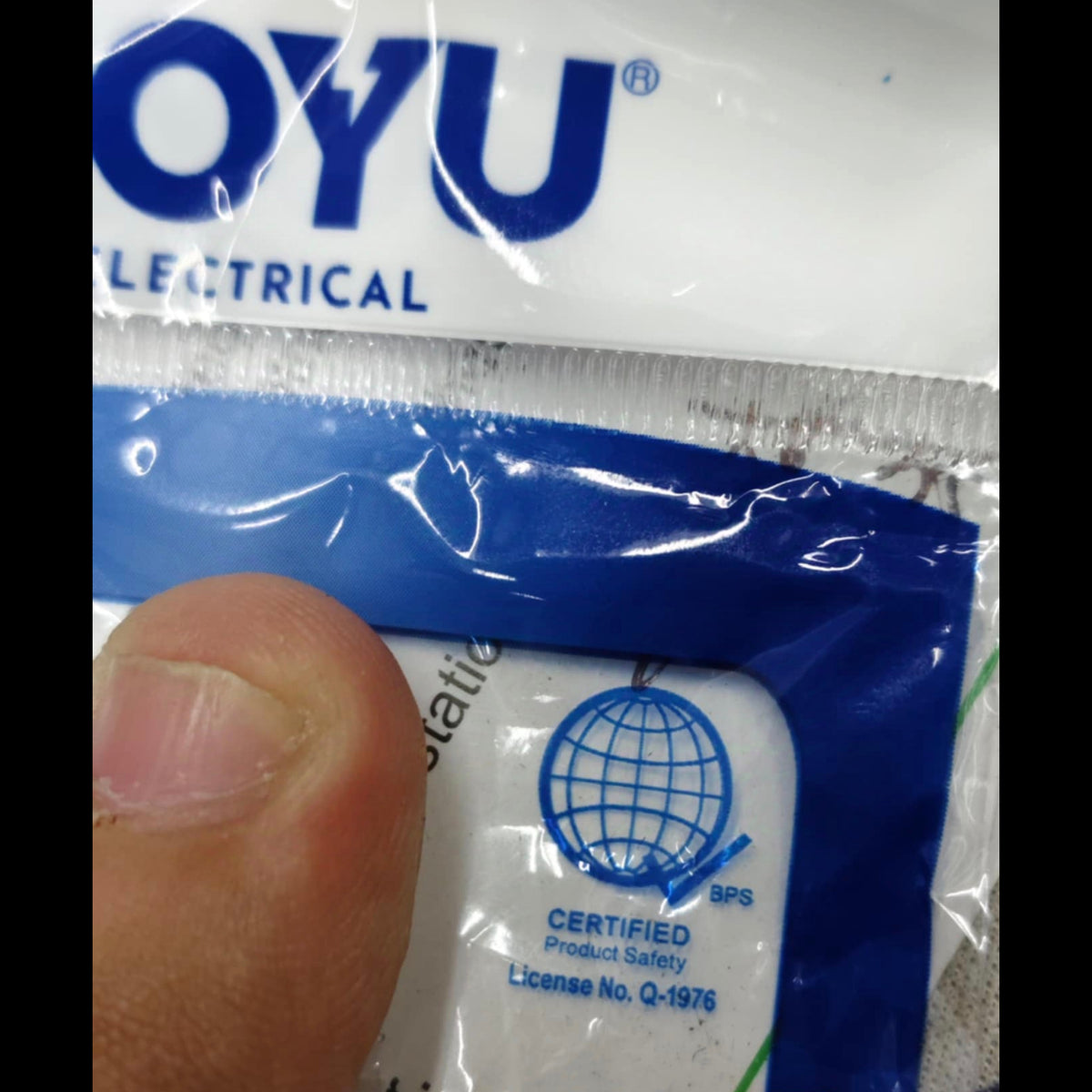Close up of Royu 3 gang flat pin outlet packaging with brand logo and certified product safety label