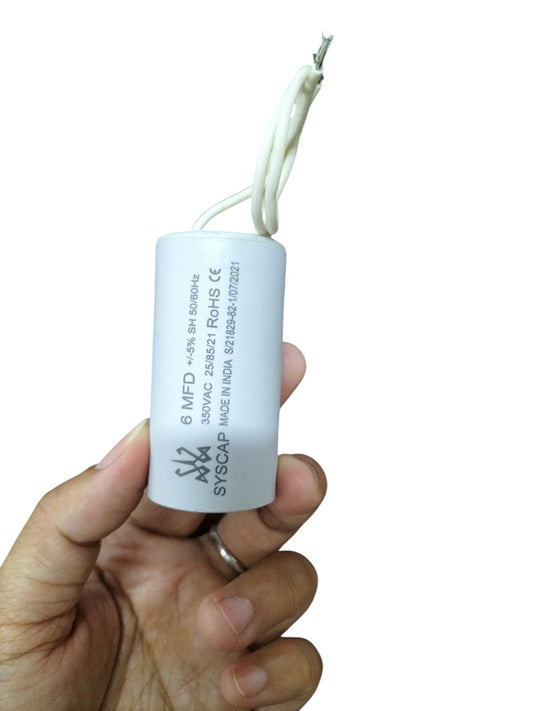 SYSCAP 350VAC Capacitor for Motors held in hand with white cylindrical body and connecting wires