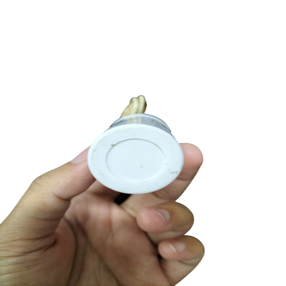 Hand holding a SYSCAP 350VAC running capacitor with clear plastic casing and connection wires