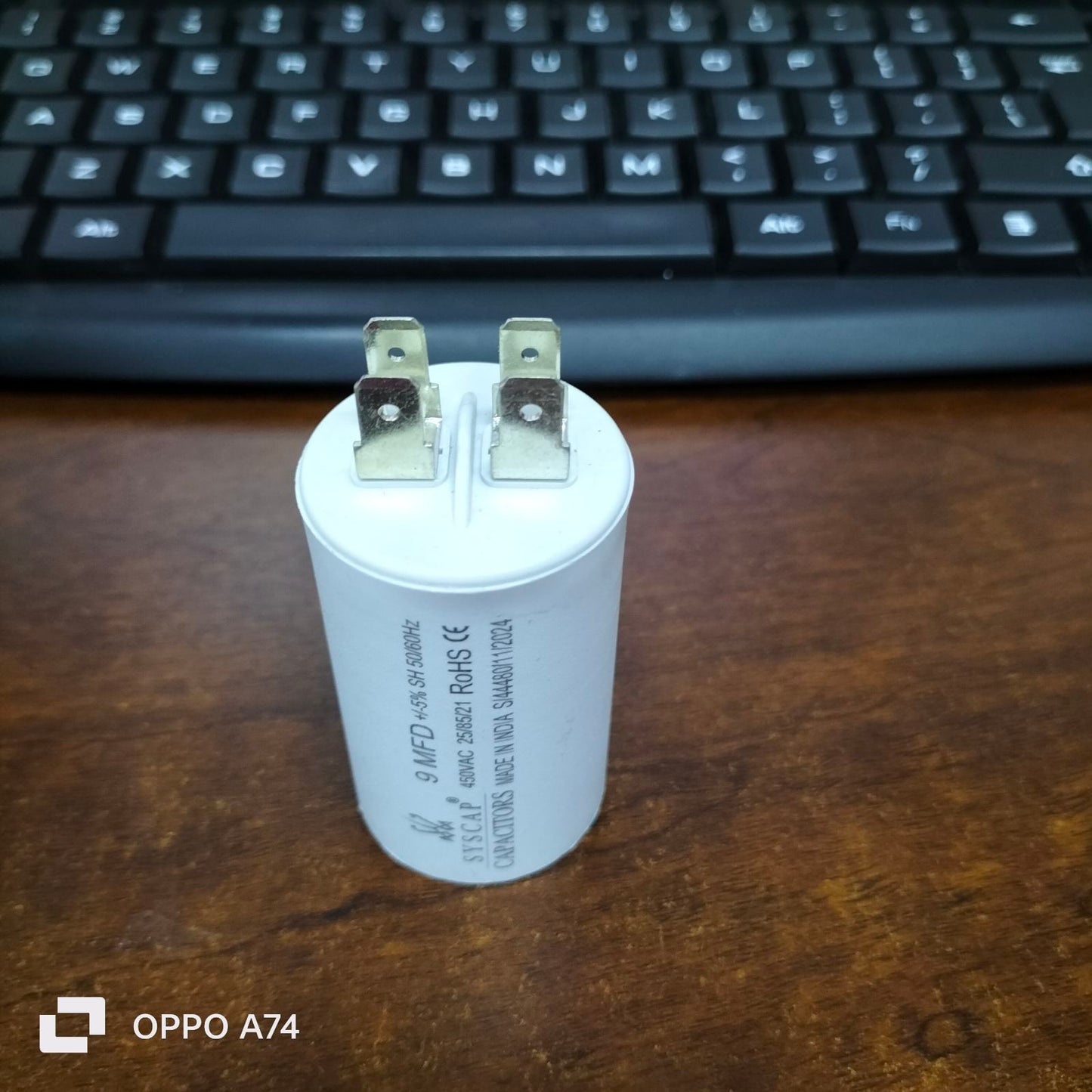 Syscap 9MFD 450 VAC Running Capacitor white cylindrical electrical part with metal terminals on wooden desk