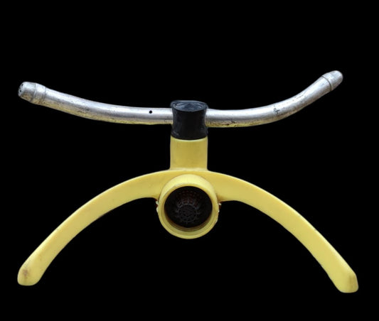 Yellow and silver garden hose sprinkler with curved legs and central nozzle for lawn watering