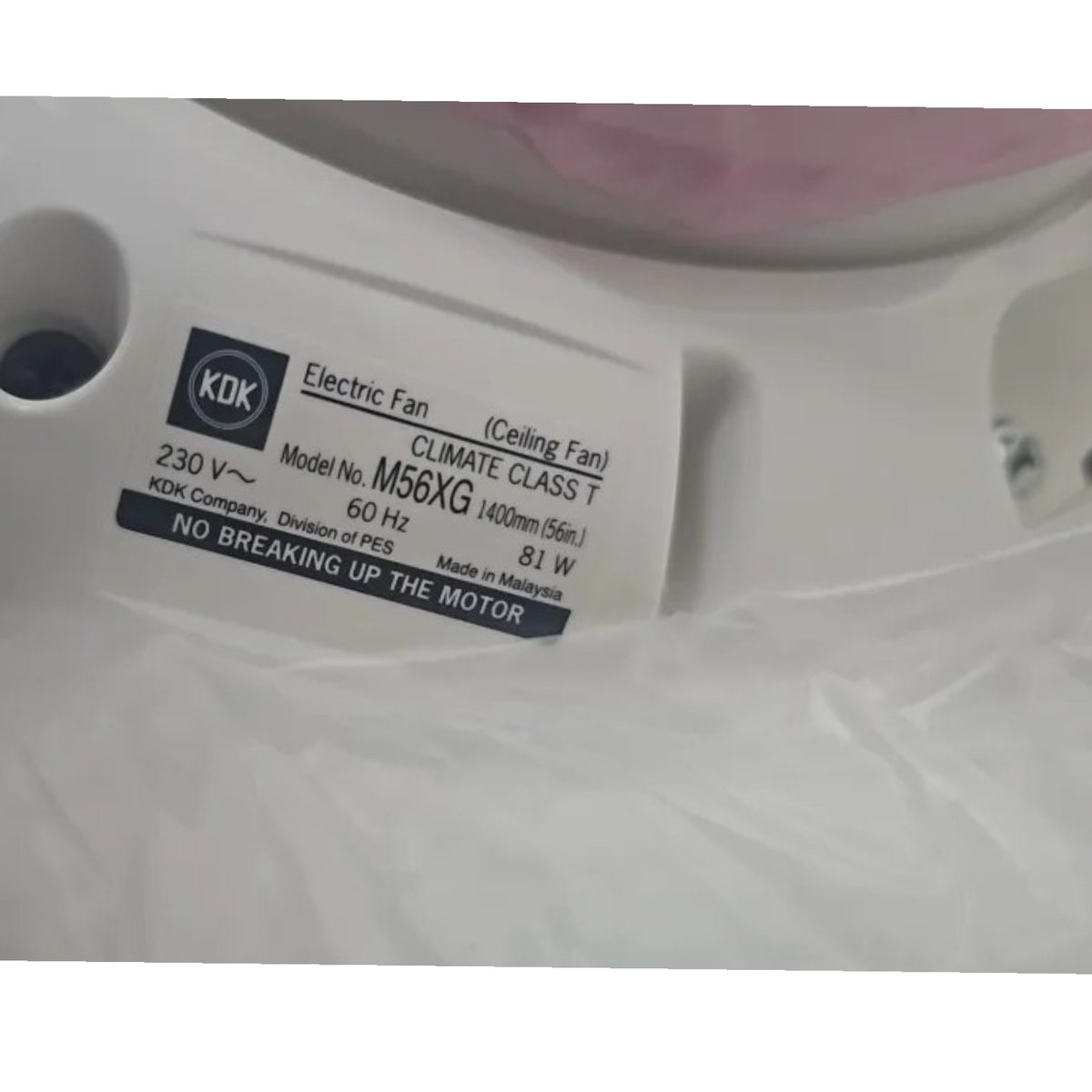 A close-up of a white ceiling fan housing with a black and white KDK label identifying the model as M56XG and the brand as KDK.