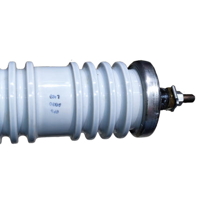 A close-up of a white ceramic high-voltage insulator with a metallic silver and bronze terminal cap on a white background.