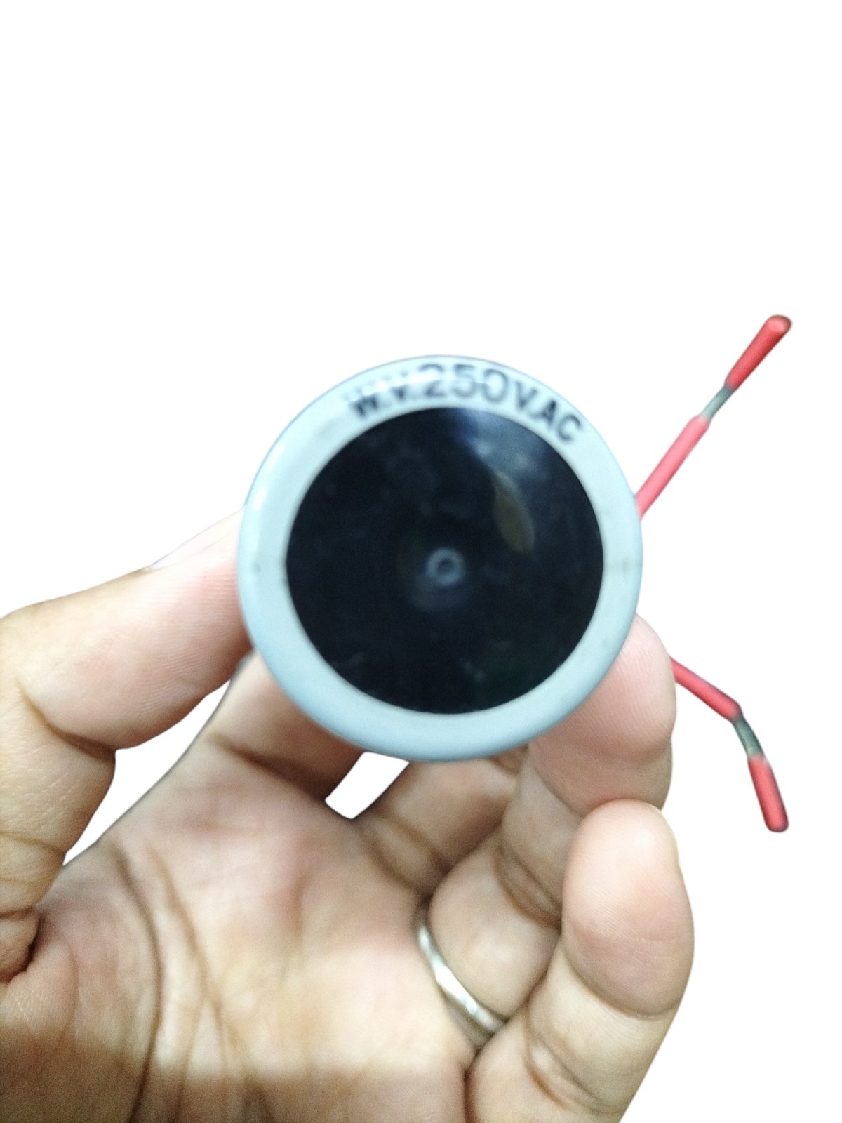 1MFD 250V AC motor running capacitor held in hand for electrical circuit applications