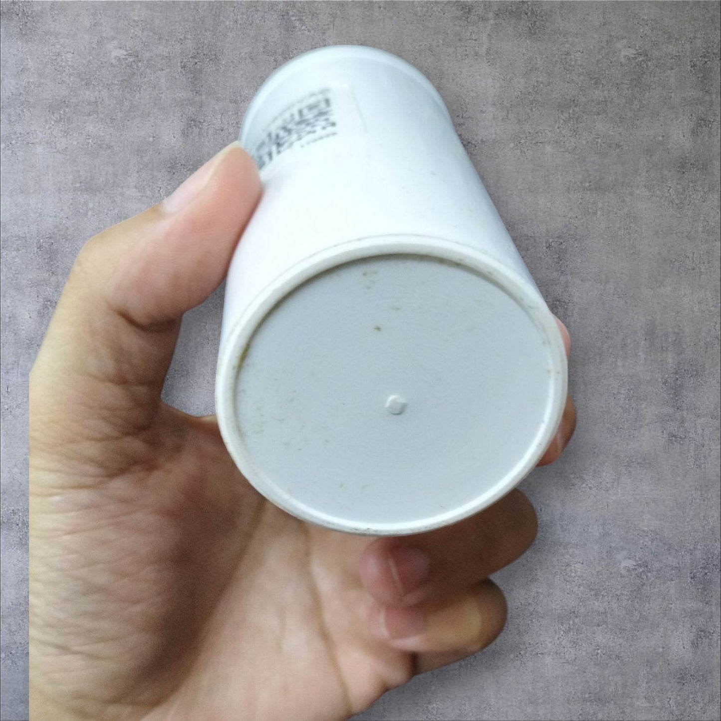 Hand holding a white 20MFD motor running capacitor 600V suitable for electrical applications