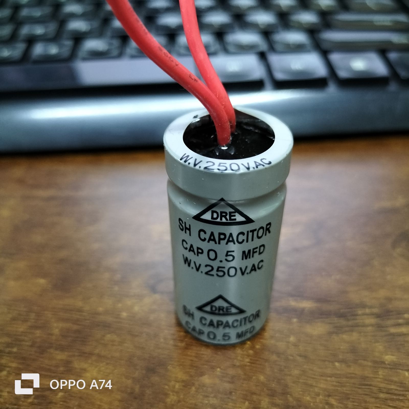 DRE 250 VAC Motor Running Capacitor with red wires and a silver cylindrical body