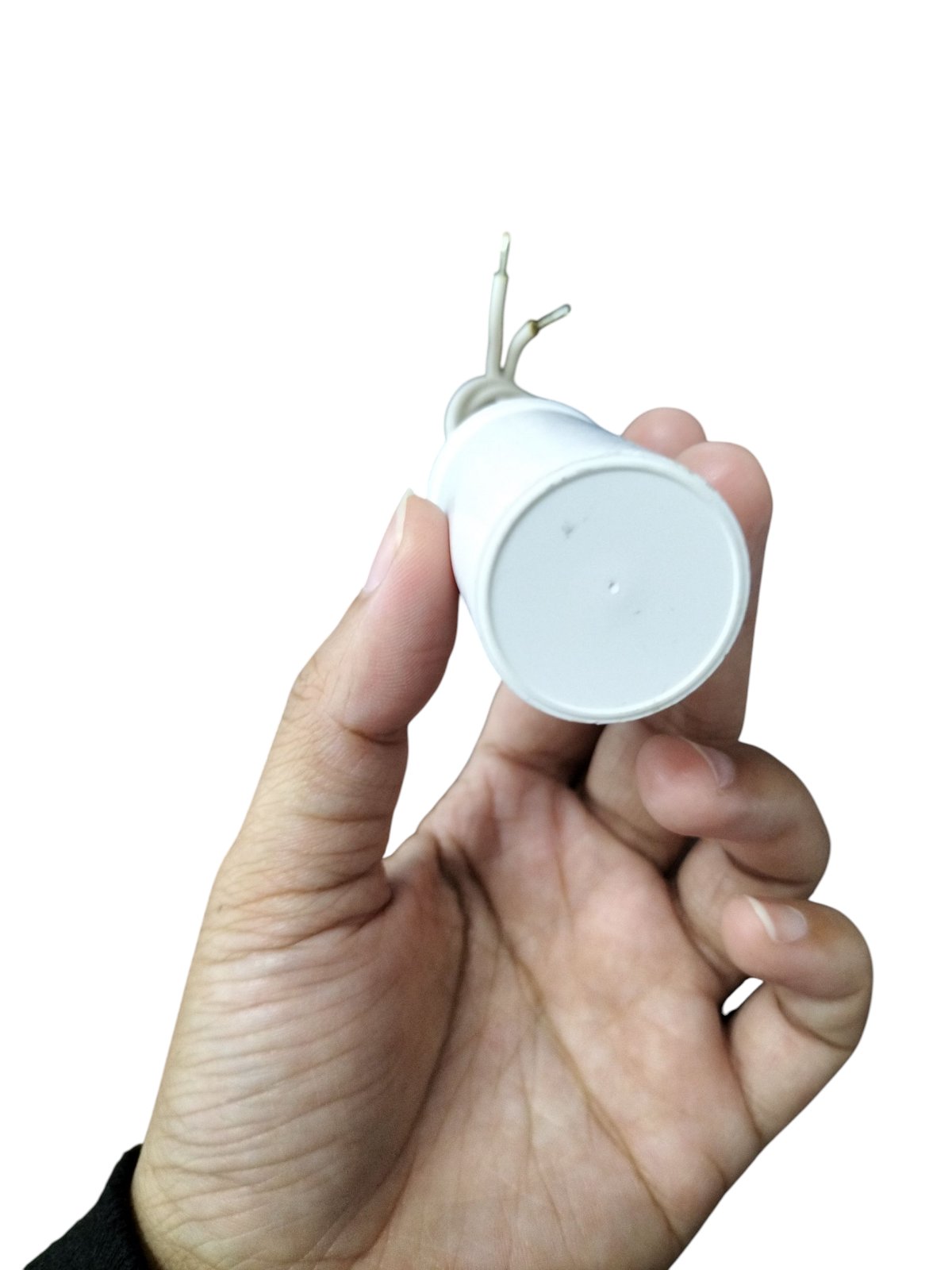 Hand holding a Syscap 250V AC Motor Running Capacitor with two wire leads for electrical applications