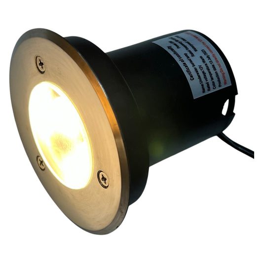 In-ground light fixture with gold and black design on a white background
