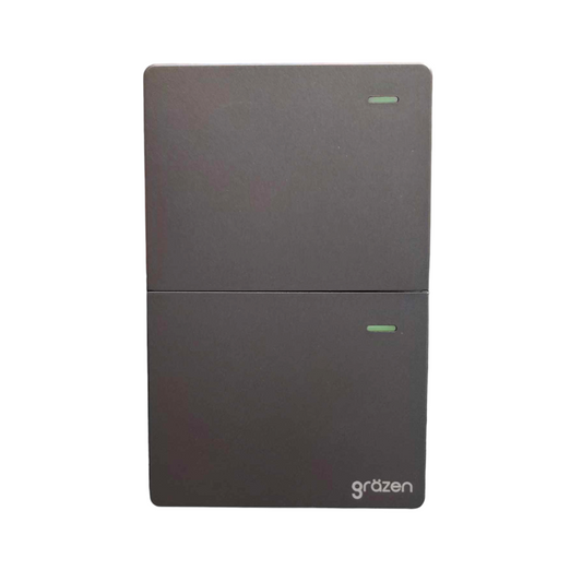 A dark gray two-door electronic device, likely a power supply or control unit, with a split horizontal design and a small green indicator light on each door. The brand name 'grözen' is printed in white near the bottom right corner of the lower door, set against a plain white background.