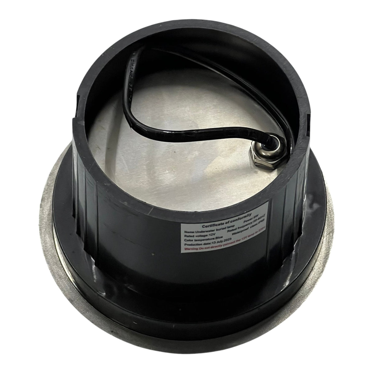 Black metal component with a label on a white background