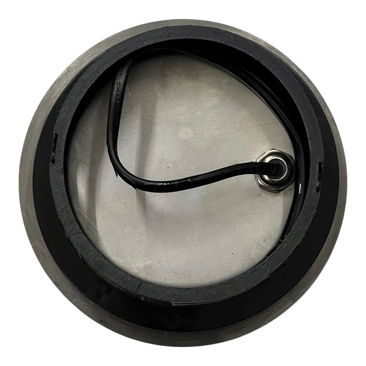 Round metal component with a black handle on a white background
