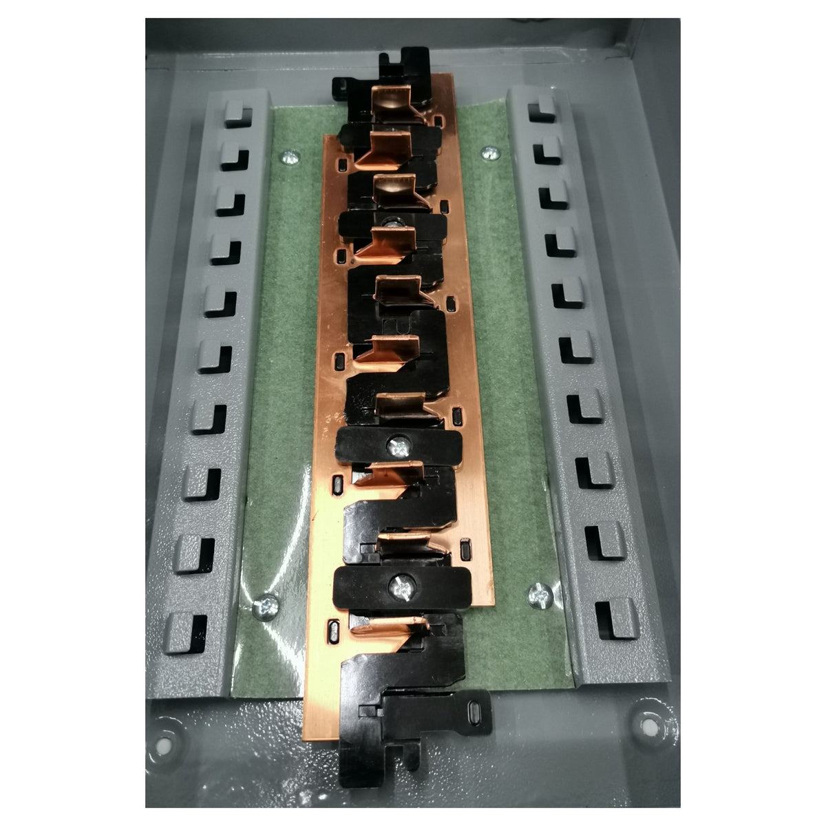 Electronic component with copper and black metal parts on a green and gray background