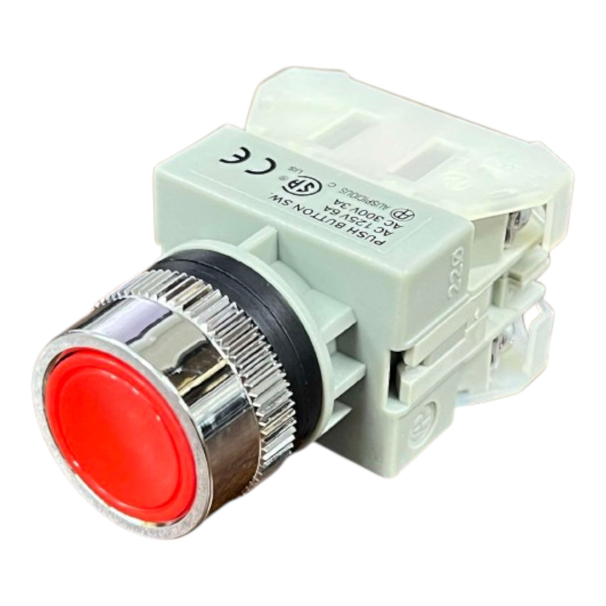 A push-button switch module with a prominent red front button and a shiny silver metal bezel, mounted on a light gray plastic housing.