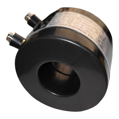 A black metal current transformer with a silver-colored engraved nameplate and two terminal connectors, shown on a plain white background.