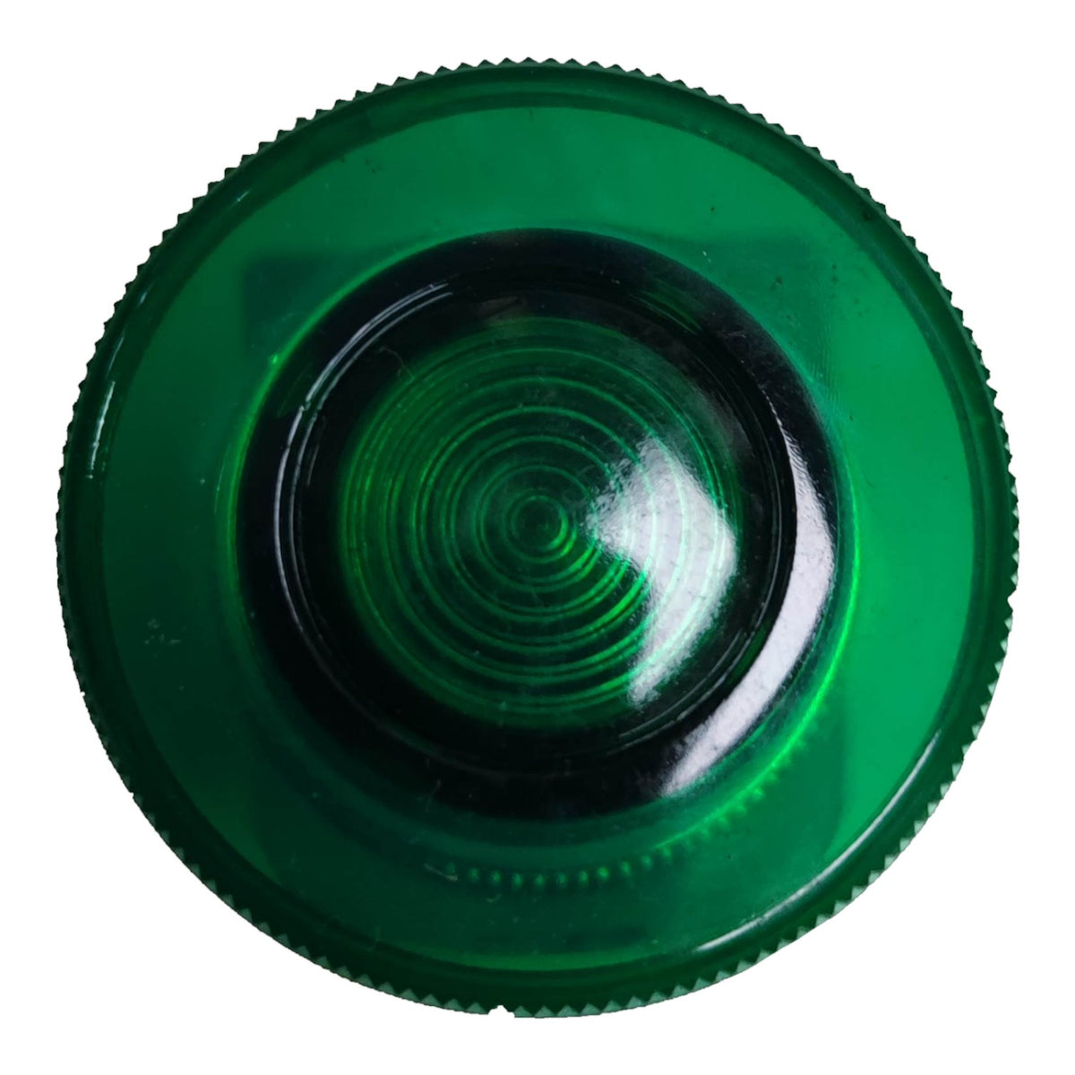 A circular green plastic lens or cover with a textured, ridged outer edge and concentric circular grooves in the center, shown on a plain white background.