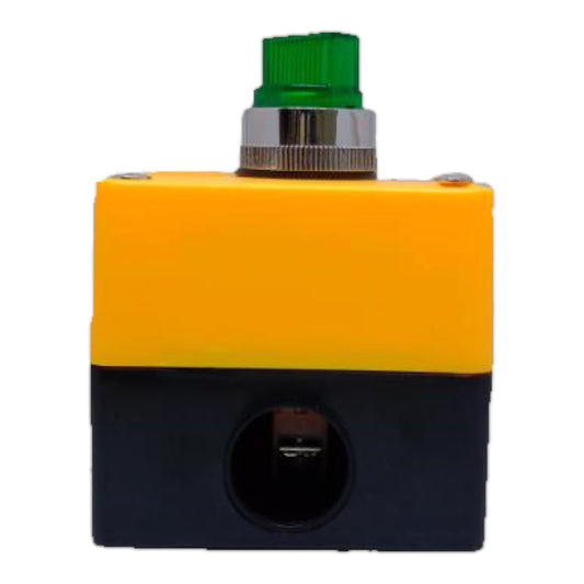 A small industrial electrical component with a two-tone yellow and black plastic housing, featuring a green ribbed button on top and a circular terminal port on the front.