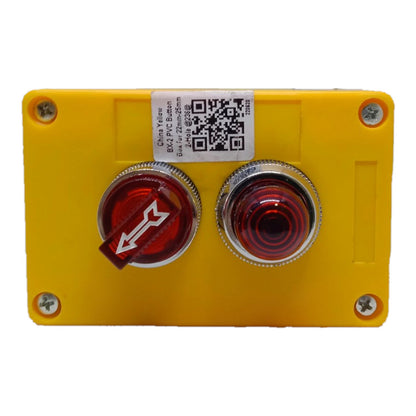 A yellow emergency stop push button enclosure with a red directional rocker switch and a second red push button, secured with four silver screws on a white background.