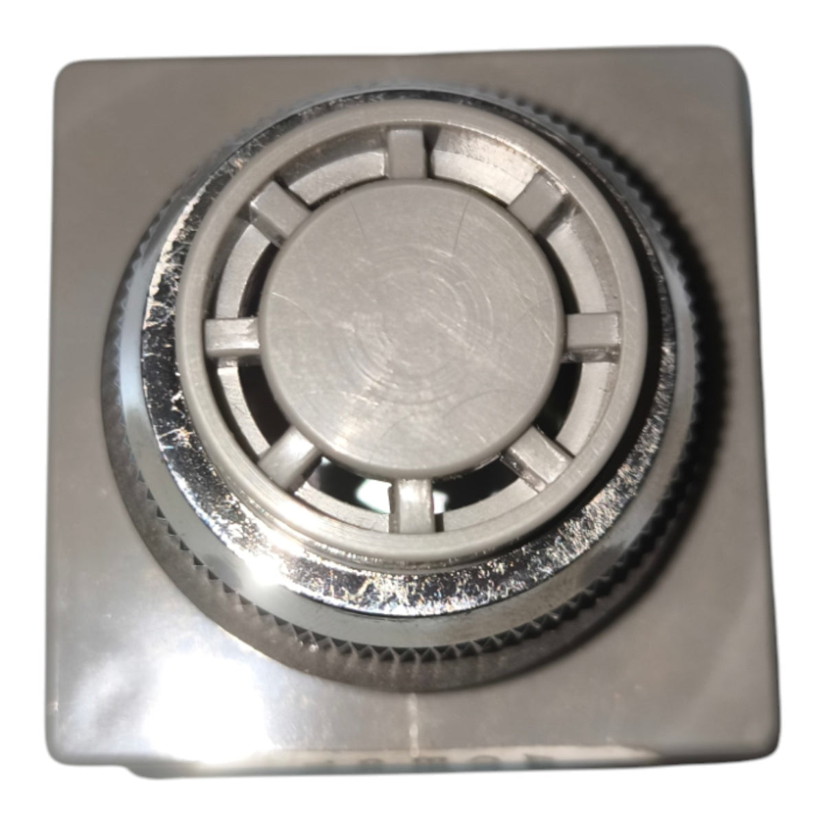 A square metallic silver control knob with a textured outer ring and a circular center, shown on a plain white background.