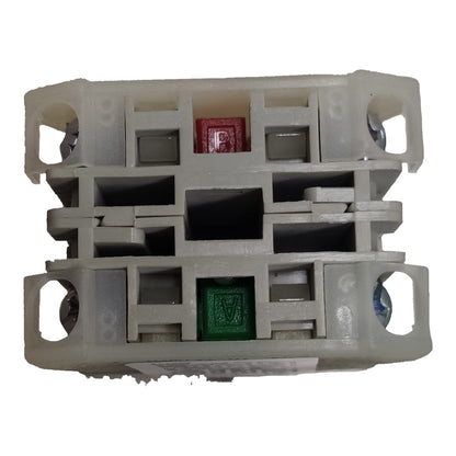 A plastic fuse holder or fuse compartment with two visible fuses, one red and one green, set against a plain white background.