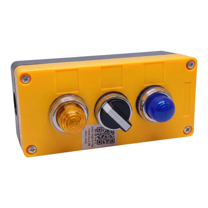 A yellow industrial control panel box with three front buttons: a yellow push button, a black rotary switch with a white tab, and a blue push button. The panel is secured with four corner screws and has a white label with a QR code in the center.