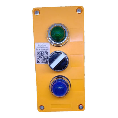 A yellow industrial control panel featuring three vertically aligned push buttons: a green button on top, a black and white diagonal button in the middle, and a blue button on the bottom. The panel is secured with four screws and includes a small white label with a QR code and text.