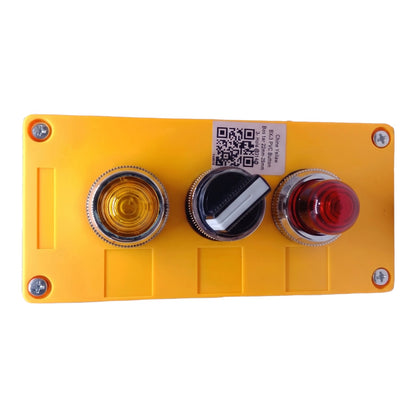 A yellow industrial control panel with three circular buttons: a yellow amber light, a black rotary switch, and a red push-button, shown on a white background.
