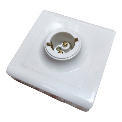 A white ceramic or porcelain electrical outlet cover plate with a three-pin socket visible in the center, shown on a plain white background.